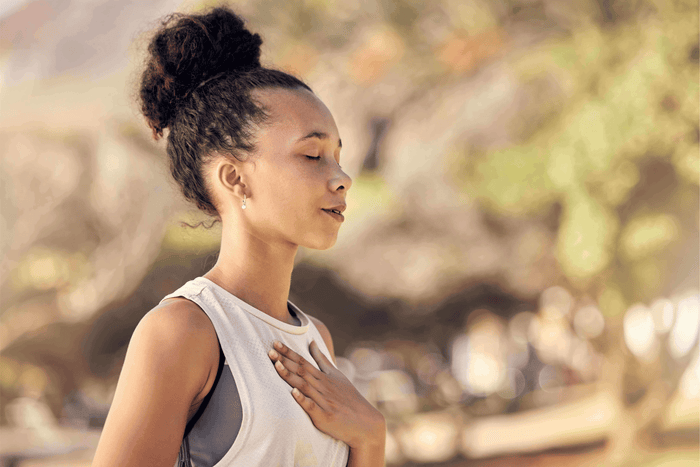 Woman outdoors with hand on chest practicing heart health awareness during American Heart Month
