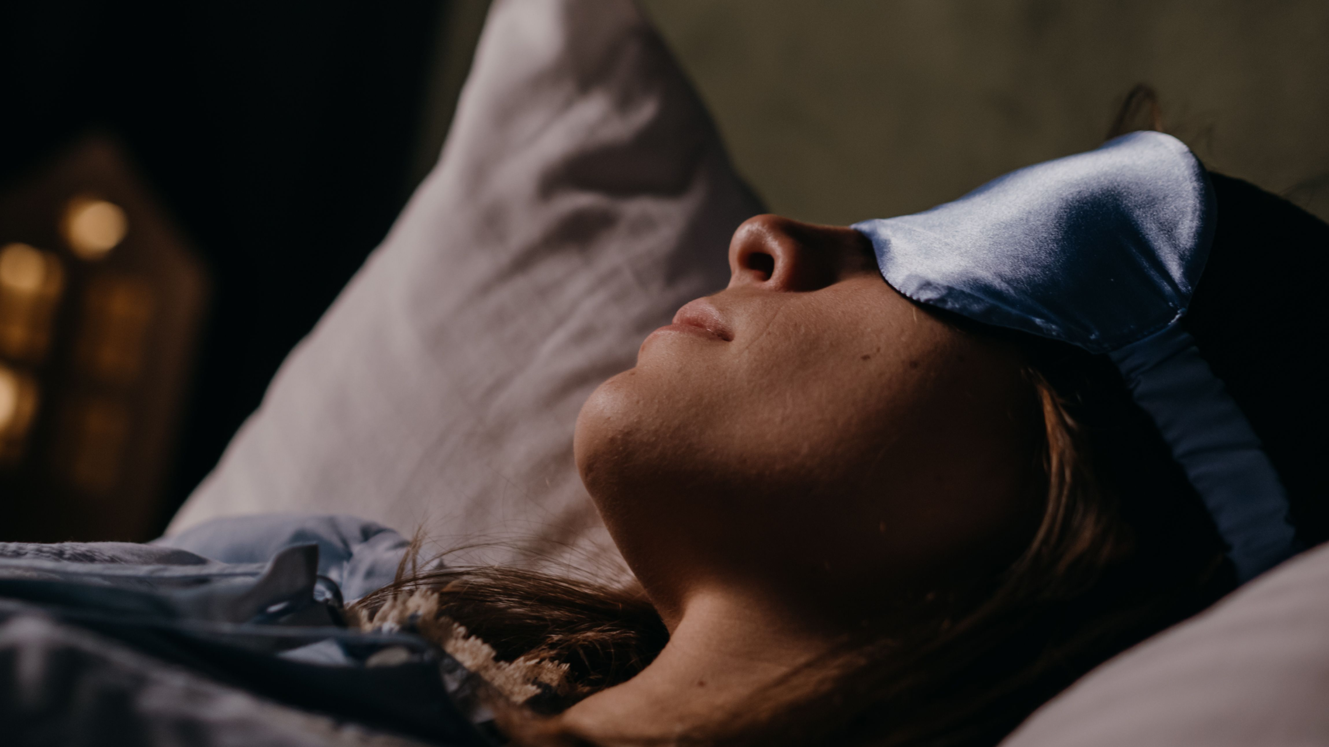 a woman sleeping wearing an eye mask