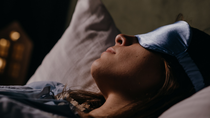 a woman sleeping wearing an eye mask